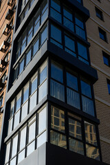 Obraz premium Modern building corner with large glass windows and brick facade