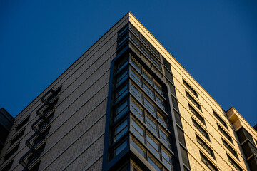 Obraz premium Modern residential building exterior with geometric design against blue sky