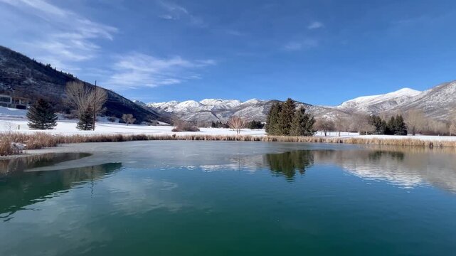 Wide pan-Wasatch Mountain State Park-Lake and Snow Capped Mountain Range Reflection on a  blue sky day.