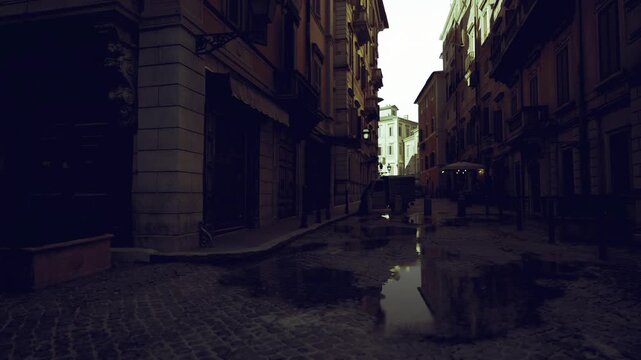 Quiet narrow street at twilight with parked delivery van, wet cobbles reflecting light, closed storefronts, urban logistics vibe, muted cinematic tones