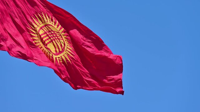 Beautiful view of Kyrgyzstan flag waving set against a blue sky in Bishkek