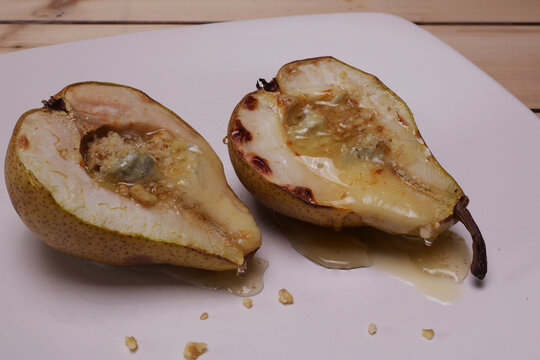 Piatto con pere cotte al forno ripiene di formaggio, granella di noci e miele
