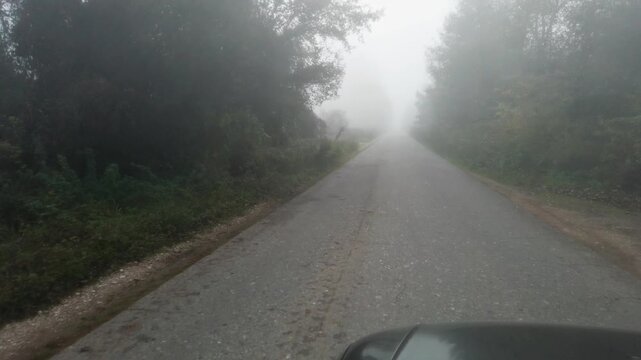 Pov driving through fog low visibility dangerous rural road