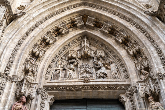 Gothic cathedral arch with sculptures in Seville, Spain