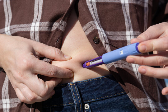 insulin injection pen semaglutide medication blue medical device of slim woman injecting abdomen with glp 1 diabetes treatment at home natural light healthy lifestyle with copy space for banner design