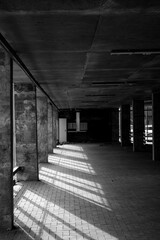 Empty industrial space with concrete walls and sunlight shadows on floor