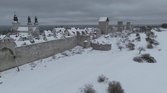 Winter Drone Flight Along Snow Covered Visby City Wall and Dalmansporten in &Ouml;stergravar, Gotland Sweden