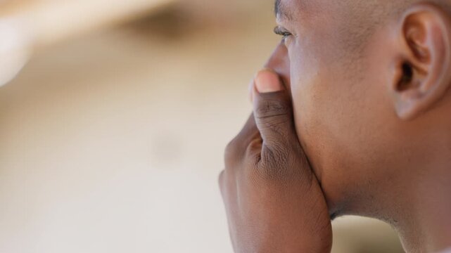 Athlete breathing into hands between sets, closeup of mouth and fingers, gentle exhale, towel wiping sweat, checking cheek and jaw, slow recovery pause after intense drill, sidelines training yard