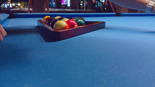Woman Placing Pool Balls Into Wooden Triangle Rack On Blue Billiard Table Before Break Shot