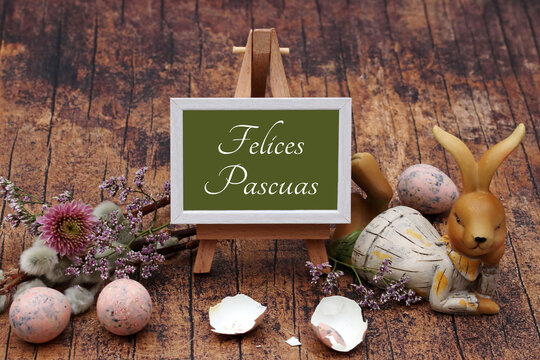 Felices Pascuas. Pizarra decorada con flores, huevos de Pascua y un conejito de Pascua.