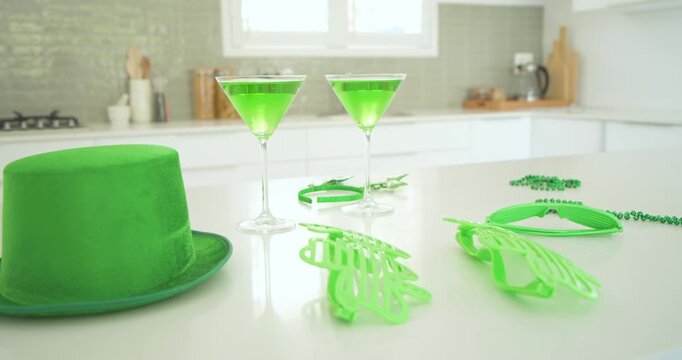 Camera is panning right on white counter, centering martini glasses and moving green props to show
