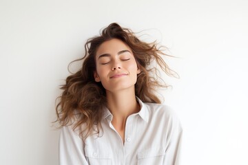 Obraz premium Woman feeling serene and tranquil with her eyes closed against a neutral background