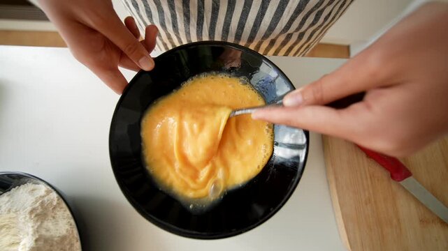 Focused trainee refining whisk skills at culinary training environment