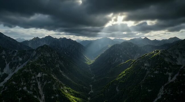 Sunbeams pierce dark clouds, illuminating a dramatic mountain valley