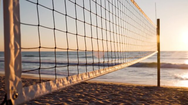 Beach volleyball net stands against a beautiful ocean sunset with soft waves gently rolling onto the sandy shore, creating a tranquil scene in motion video footage.