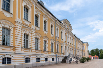 Fototapeta premium A palace building with yellow walls and a staircase at the entrance. Several bicycles are parked near the house