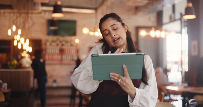 Waitress, talk or phone call in diner with tablet, booking website or digital app for online order. Bokeh, woman and conversation in restaurant with tech, contact or reservation for customer service.