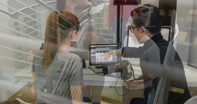 Man tapping laptop, selecting thumbnails and activating animated tags, mentoring woman on camera