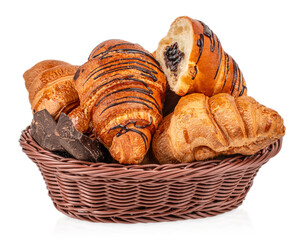 Fresh assortment of croissants including chocolate filled pastries served in wicker basket, isolated