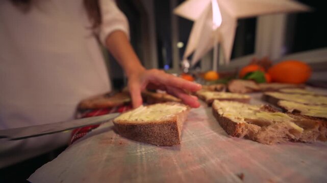 Close view of hands spreading creamy butter on crispy toasted bread slices