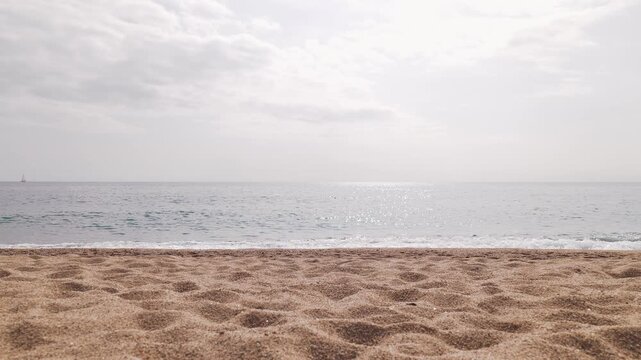 Peaceful empty beach with smooth sand, calm sea, and bright sky, symbolizing tranquility, freedom, and natural beauty.