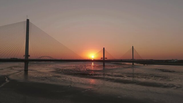 Liverpool, Merseyside, UK, June 19, 2025; Aerial 4K video footage of the Mersey Gateway toll bridge with stunning views over the River Mersey, Liverpool, UK.