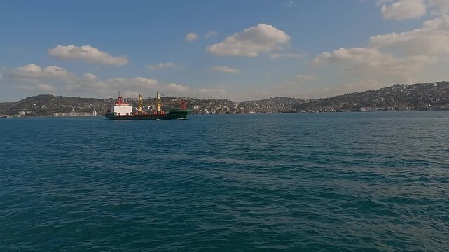 Cargo ship tanker in Bosphorus Strait about to pass under Bosphorus bridge. Istanbul Turkey. Shipping on the bosphorus. Concept of sea freight transport. Passage of cargo ships through the Strait.
