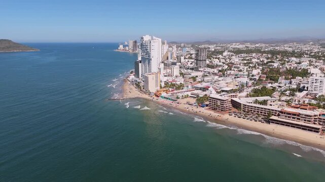 Vista aerea de edifico en la costa del pacifico gravado en 4k y 60fps, mostrando el mar y el cielo en el horizonte de un dia soleado.