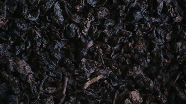 Dark, dry oolong tea leaves spinning in detailed top down view, showcasing rich texture and natural ingredients perfect for healthy, antioxidant rich beverage or a traditional tea ceremony. Gabba tea