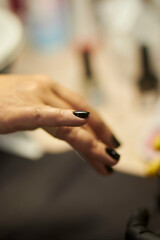 Obraz premium Women's manicure. Female hand undergoing a manicure procedure. The master does a women's manicure. A manicurist files a women's nails in a salon. Hygiene and hand care for woman. manicure design.