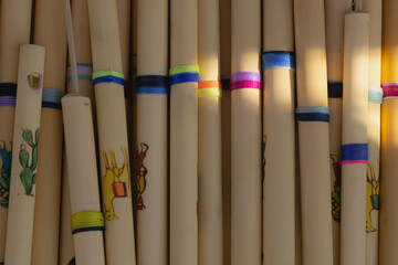 Handcrafted wooden flutes displayed in market stall under warm sunlight © Miroslav