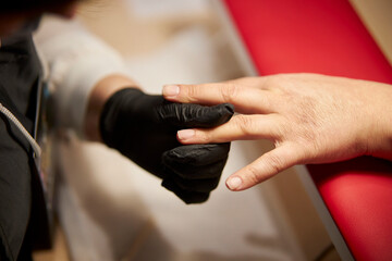 Women's manicure. Female hand undergoing a manicure procedure. The master does a women's manicure. A manicurist files a women's nails in a salon. Hygiene and hand care for woman. manicure design.