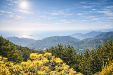 Fototapeta premium A panoramic view of a mountain landscape with green hills and a seashore under bright sunshine. materials.