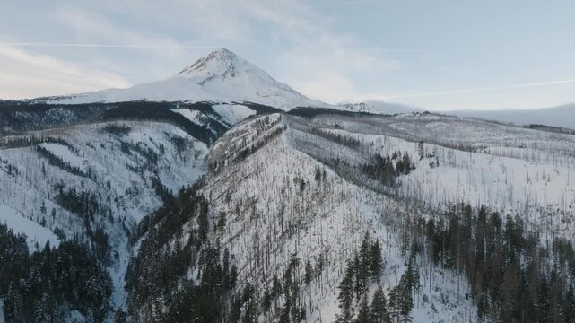 Aerial drone footage over a snow-covered volcanic mountain landscape with river valleys.