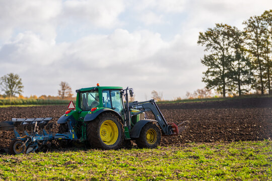 Falkenberg, Sweden - October 23 2024: Green John Deere tractor plowing a field.