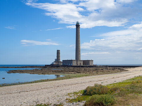 Vistas del faro de Gatteville, arquitectura imponente en la orilla de la costa sobre cielo azul con nubes blancas en la playa, viajando en verano de 2022