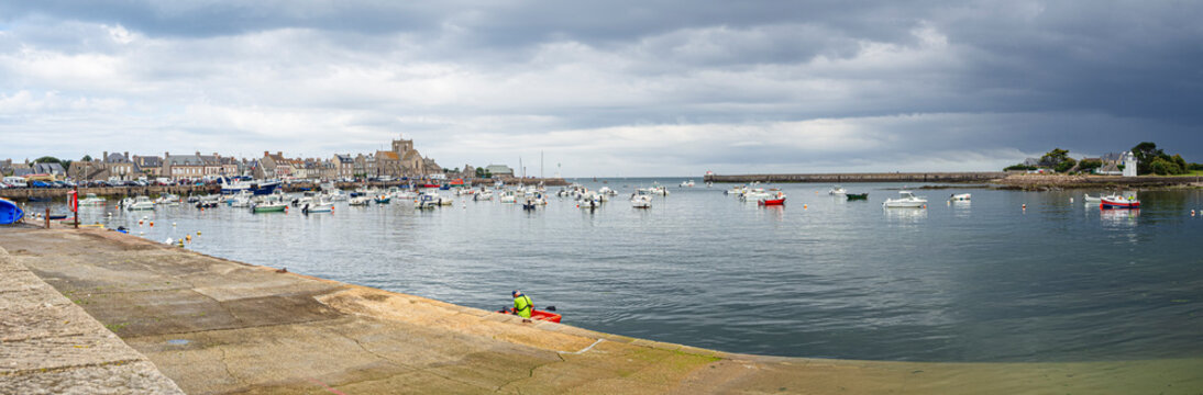 Paisaje panor&aacute;mico de la costa de Barfleur, pueblo bonito de la Normand&iacute;a francesa, con nubes oscuras sobre el mar lleno de barcas y vistas a la arena de la costa, viajando en verano 2022