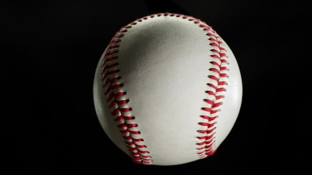 Rotating White Baseball Ball on Black Background . Filmed on High Speed Cinematic Camera at 1000 fps
