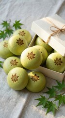 Momiji Manju, Japanese sweets. Green wagashi sweets arranged on fabric with maple leaf motifs and leaves