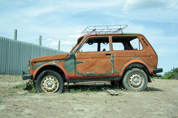 An abandoned burnt-out, rusty car after the explosion, ready for disposal. The burnt-out interior of the car, a close-up of the fire, extinguishing the fire. A burnt-out car, due to a short circuit. 