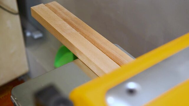 Closeup of carpenter man shaping wooden block on planer thicknesser jointer machine in workshop. Woodworking process, furniture preparation, handmade craftsmanship, precision tools, carpentry studio