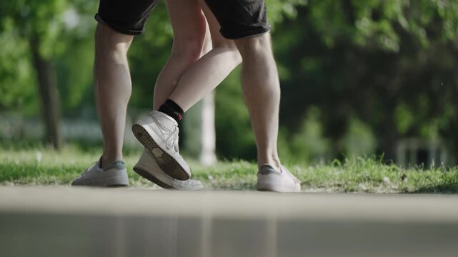 Girl and boy dancing on the dance floor in park, cinematic selective focus footage in slow motion