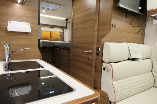 Detail of kitchen corner, rear seats and bedroom in modern german camper van Carthago C55i, model 2026, displayed on Caravan Bike Travel expo in NItra, Slovakia. 