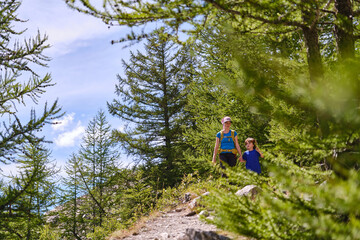Obraz premium A family enjoying the forest together. The mother and young child walk together holding hands.