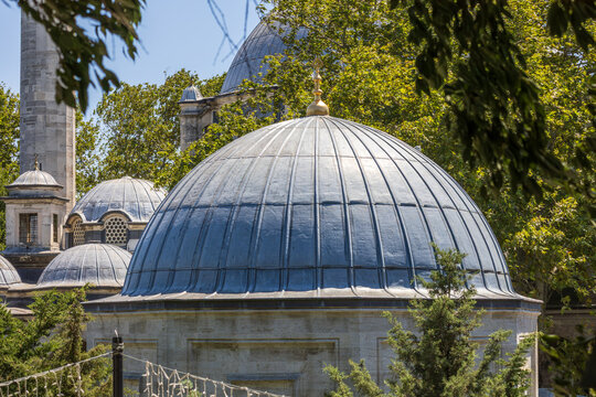 Small dome beside Ey&uuml;p Sultan Mosque framed by trees in Istanbul, Ottoman architectural detail