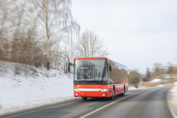 Red city bus driving on winter road. Public transport in motion. © puhimec