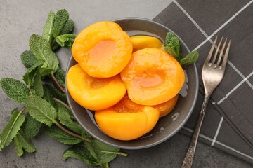 Pickled peaches and mint leaves on grey table, flat lay © New Africa