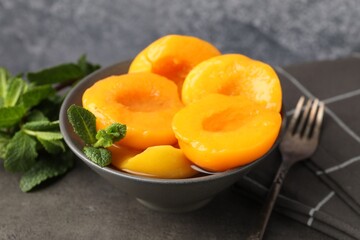 Pickled peaches and mint leaves on grey table, closeup © New Africa