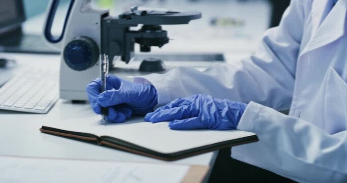 Scientist, woman and microscope with writing in lab for clinical trial, medical results or innovation. Biotech, mature person or equipment with notes for cancer research, vaccine development or study