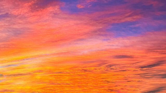 Colorful morning winter sunrise, with the dramatic clouds showing colors of orange, yellow, pink and blue, just before sunrise.